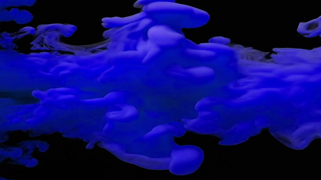 Inchiostro blu che turbina e si dissolve nell'acqua su sfondo nero