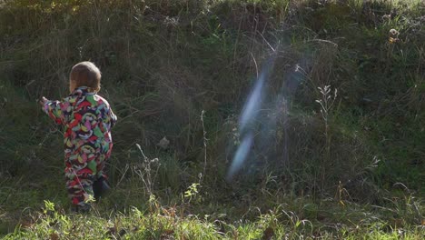 niña pequeña con ropa de colores jugando con su golden retriever de barro