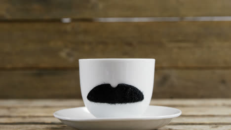 cup and saucer with fake mustache