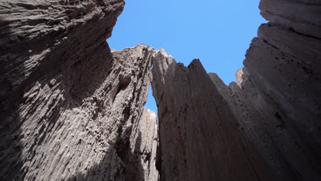 natural wonders of cathedral gorge state park, low angle view of bentonite clay cliffs in narrow slot canyon under blue sky, nevada usa