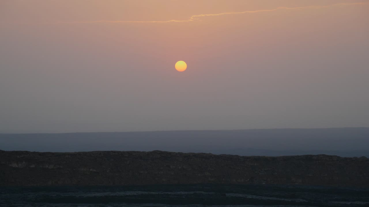 Clear view of the sun rising in the sky over the danakil depression in Ethiopia, wide shot
