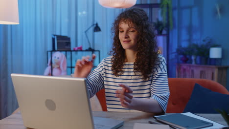 Woman-girl-freelancer-sitting-on-couch-closing-laptop-pc-after-finishing-work-in-night-room-at-home