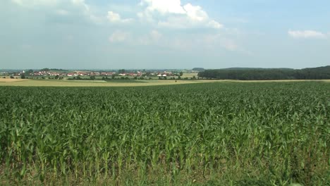 Pan-shot-across-typical-bavarian-landscape-with-fields-and-village-of-Adelshausen-in-the-back,-Bavaria,-Germany-1