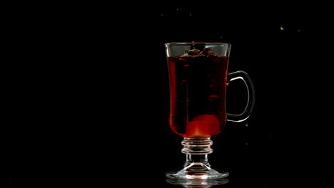 sugar cube falling into tea in a glass