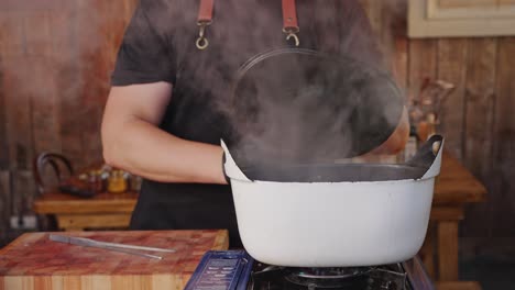 un chef hábil abriendo la tapa y sacando pulpo escalfado con una tanga de agua hirviendo, proceso de ablandamiento de la textura