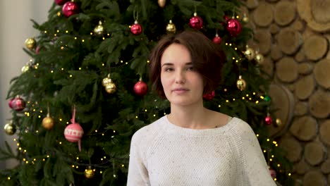 mujer envuelta en una manta a cuadros por el árbol de navidad