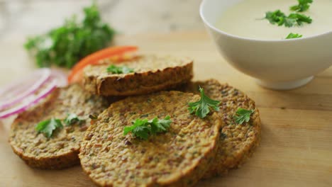 Video-of-fresh-vegetables-and-vegetarian-burgers-with-bowl-of-salsa-over-wooden-background