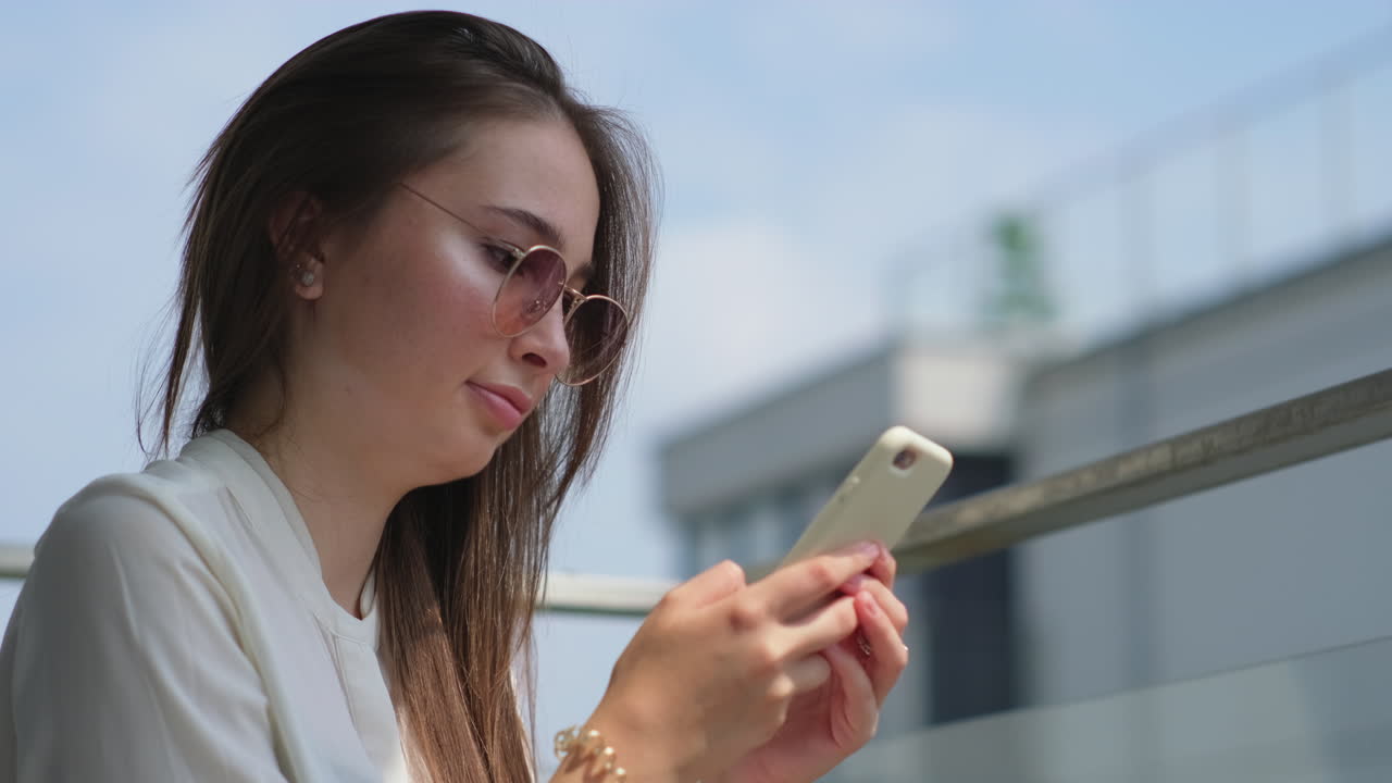 발코니에서 스마트폰을 사용하는 여자