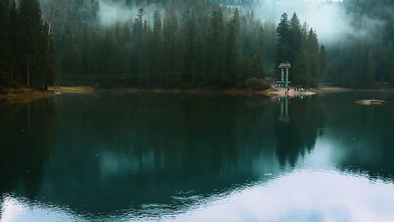 Blue lake in wild foggy forest. Mountain lake with clear water