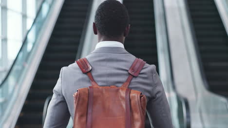 back, businessman and walking to escalator
