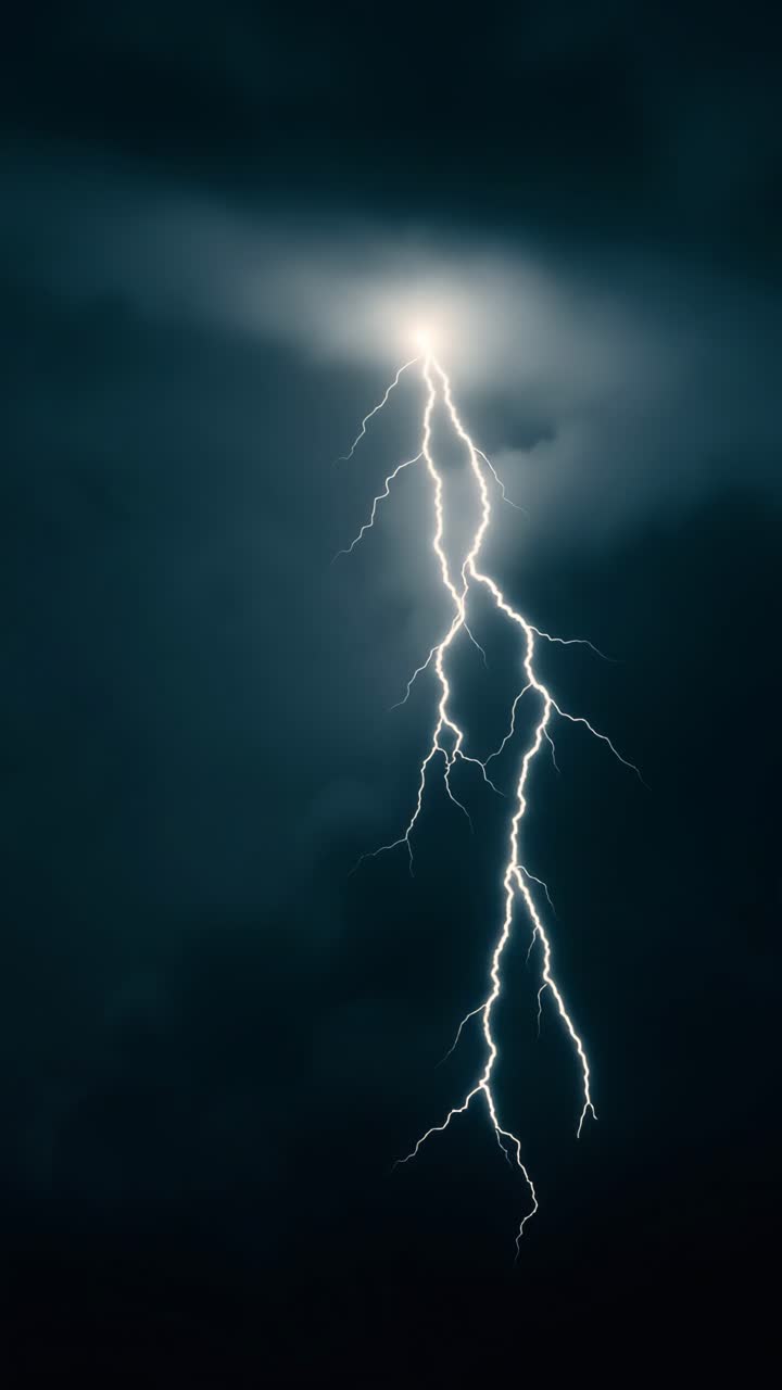 Dramatic vertical shot of a lightning bolt against a dark sky, capturing the raw power of nature