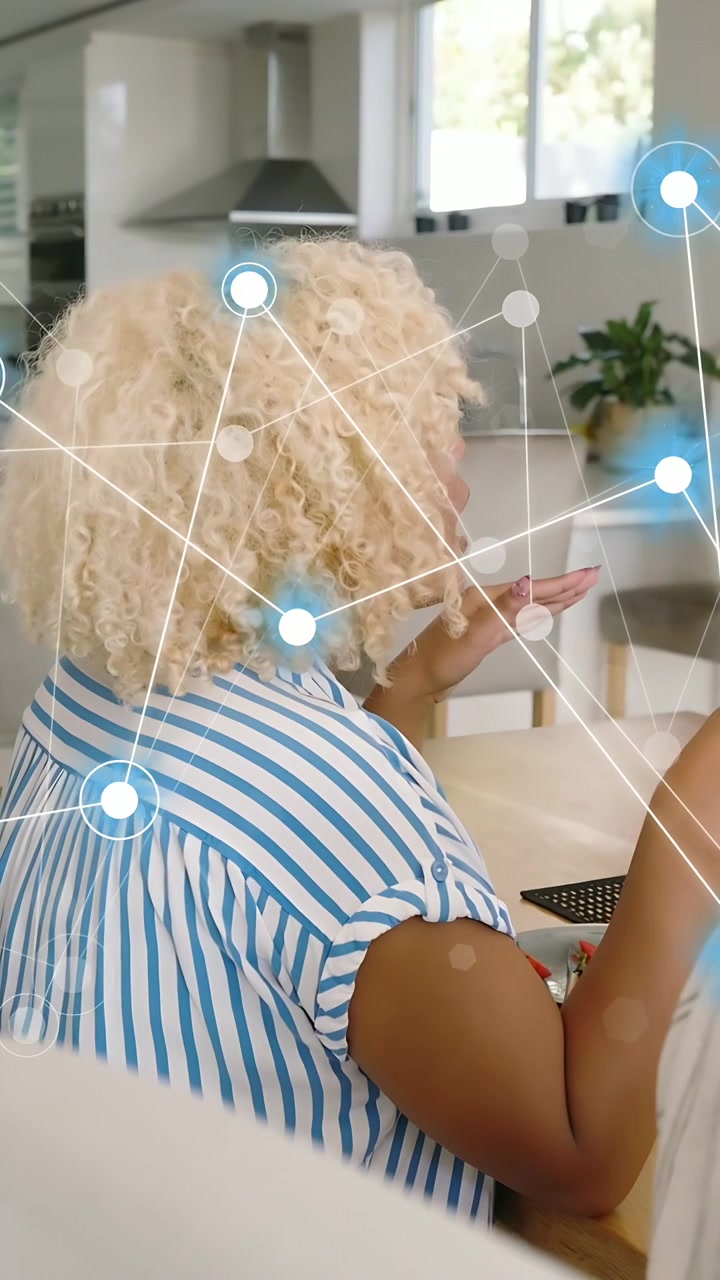 Video verticale: Donna che applaude al tavolo, animando una rete di nodi e mostrando tecnologia domestica mentre mangia.