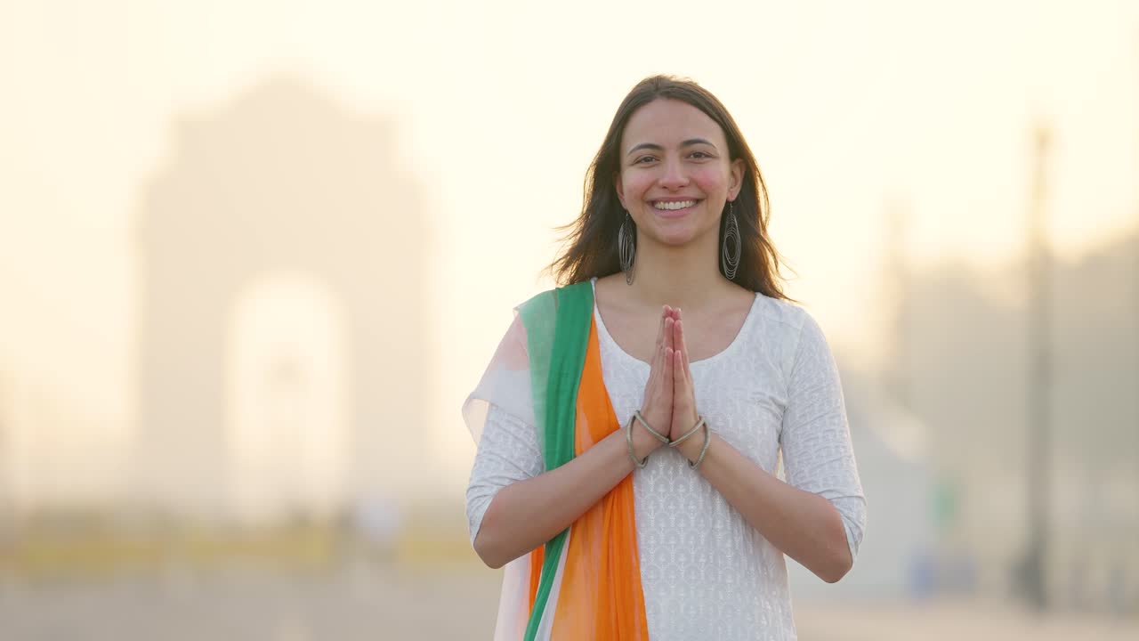 индийская девушка приветствует и делает намасте в индийском наряде у ворот индии