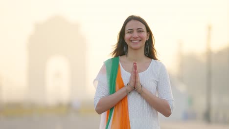 india girl greeting and doing namaste in indian outfit at india gate