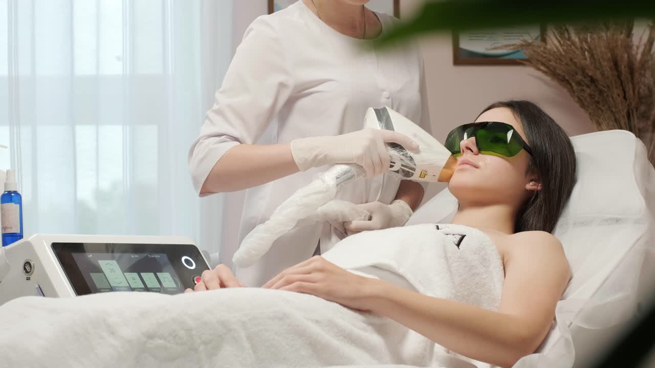 레이저 제거 - 헤어 제거 절차. 다이오드 레이저 제거의 플래시, 미용사는 아름다운 여성 다리에 머리카락을 제거합니다, 부드러운 피부를 위해 헤어 제거, 미용 스튜디오 또는 클리닉에서 레이저 절차, 신체 관리 헤어 제거 치료.