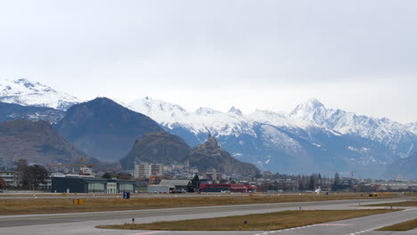 distant private jet taking off from runway at sion airport in the alps