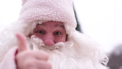 Santa Claus with a White Beard Shows the Thumb up Santa Claus with a White Beard Shows the Thumb up Christmas Character Santa Claus Ready to give Gifts to Children Face Close up