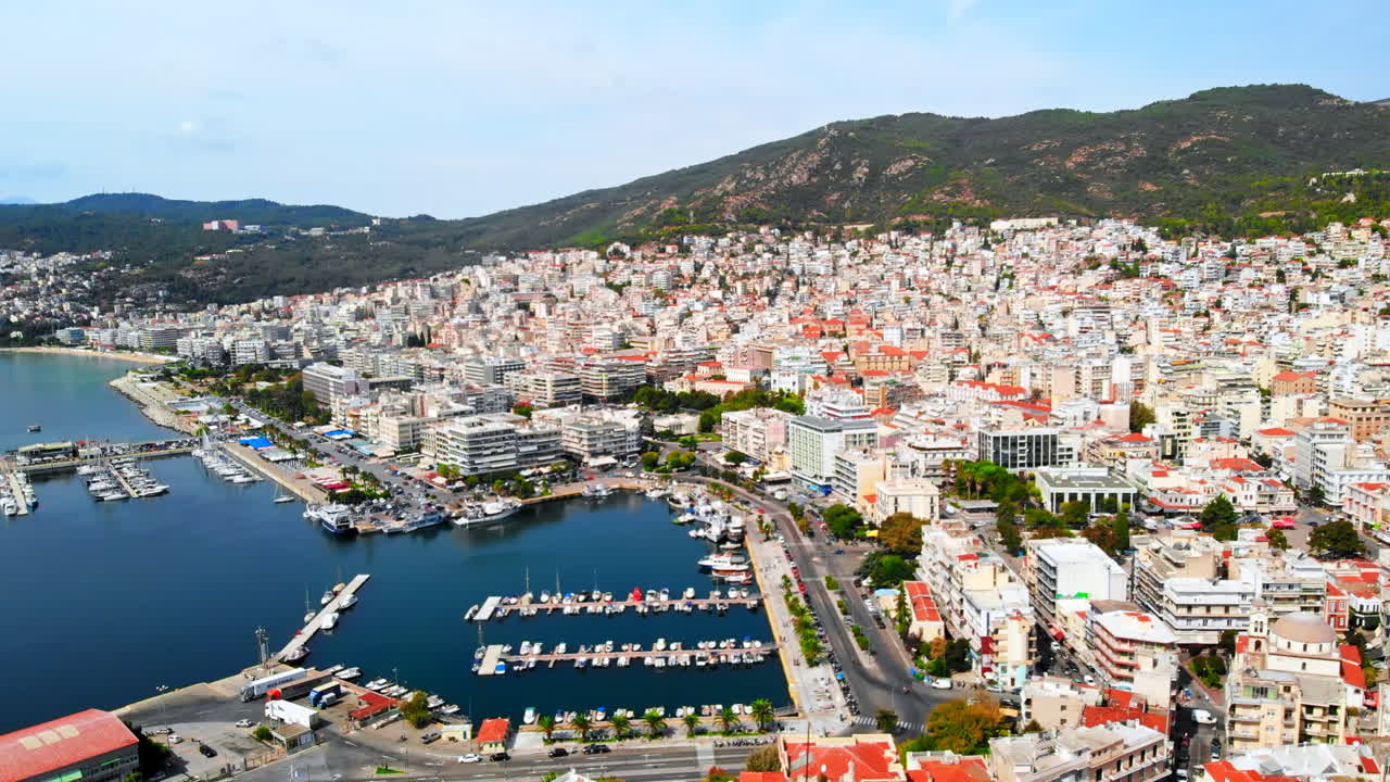 Aerial view of Kavala, a lot of buildings, Aegean sea coast, sea port, green hills in the distance, Greece