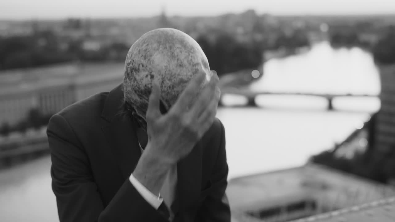 Man in Skull Mask Overlooks City from Rooftop