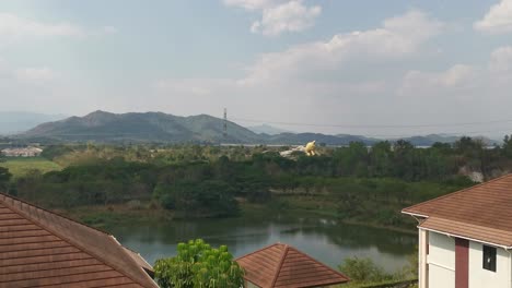 Thailands-Malerischer-Aussichtspunkt-Mit-Blick-Auf-Einen-Kleinen-See-Und-Die-Berglandschaft-In-Der-Ferne-Mit-Dachgebäuden-Im-Vordergrund