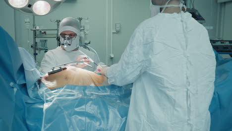 assistant gives scalpel tool to surgeon in room. cardiologists team with medical equipment at coronary artery bypass surgery in cardio clinic