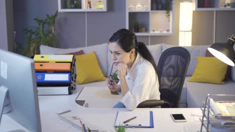 the woman looking at the computer screen is working very carefully.