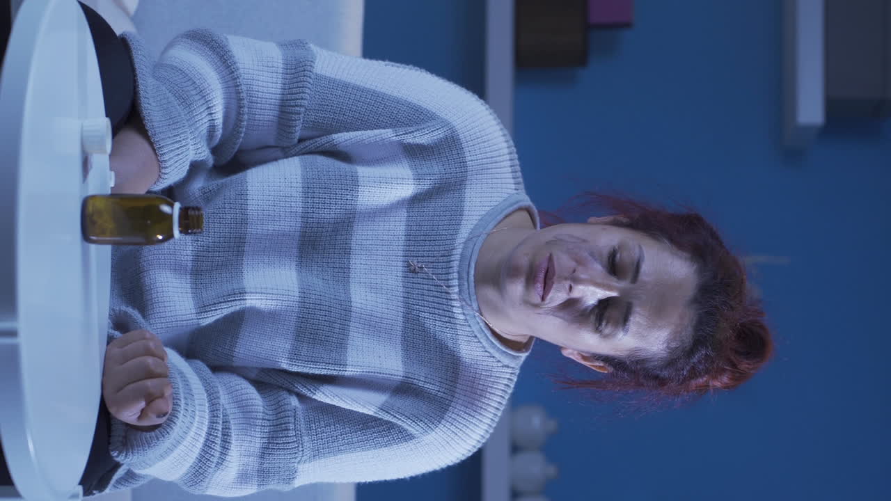 vídeo vertical de la mujer que toma las pastillas en la mesa con las manos temblando. suicidio.