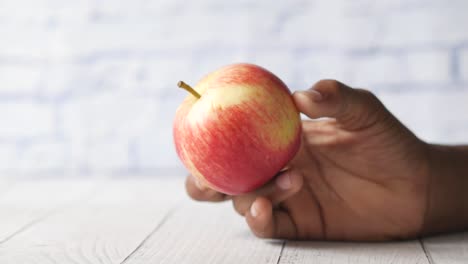 mano con una manzana roja