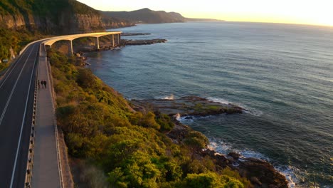 magnificent sunrise overlooking modern highway at the edge of an island in australia - aerial shot