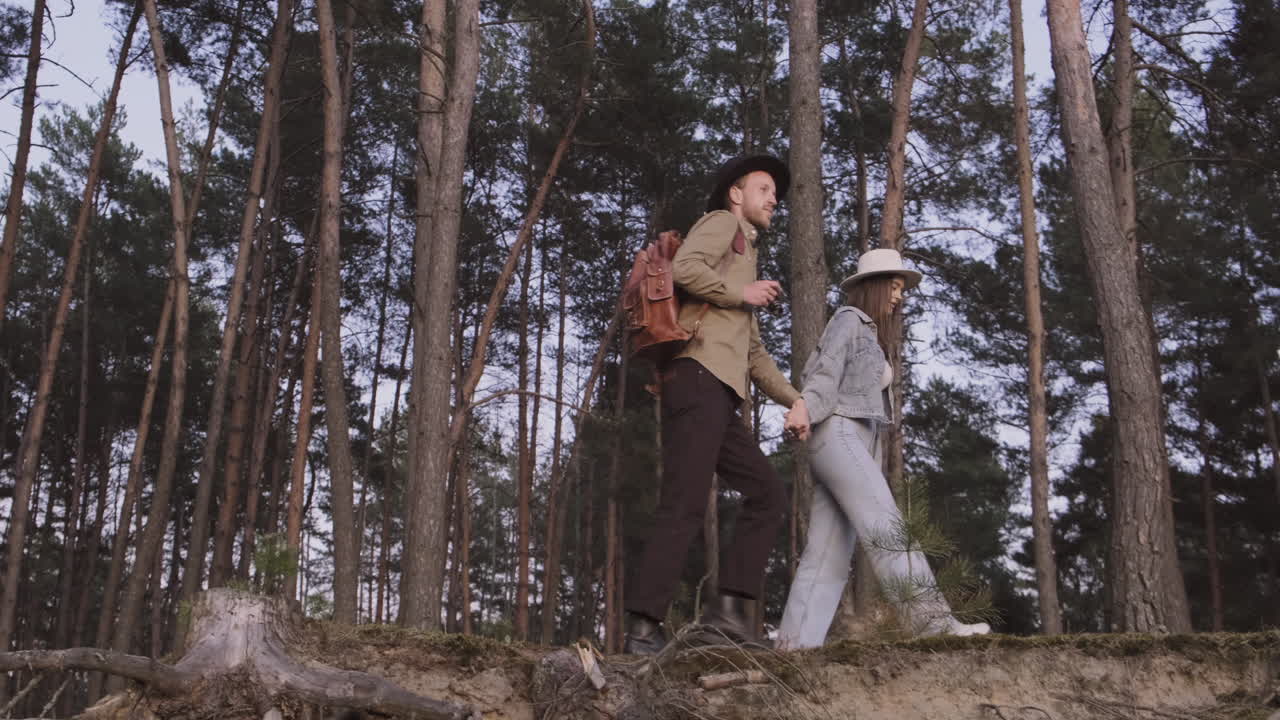 pareja dando un paseo por el bosque al atardecer