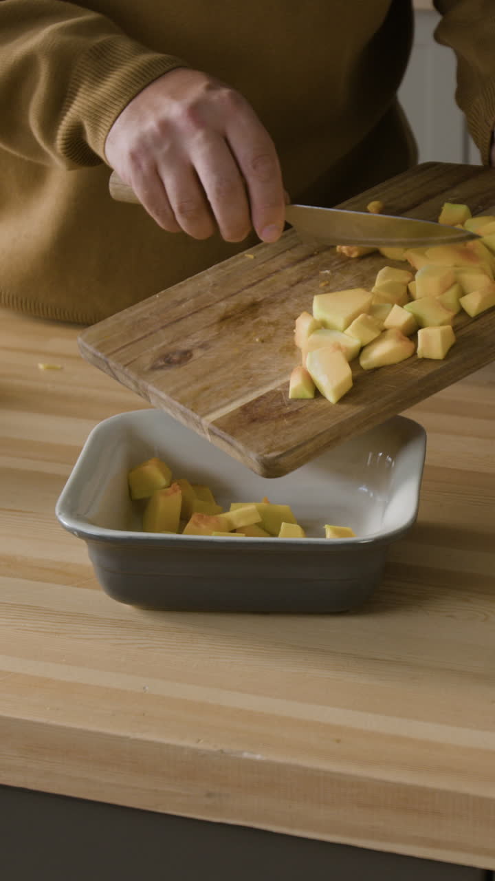 Diced Butternut Squash Being Added to Baking Dish