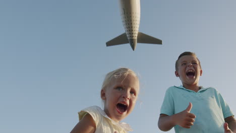 children are super excited with plane flying overhead so close