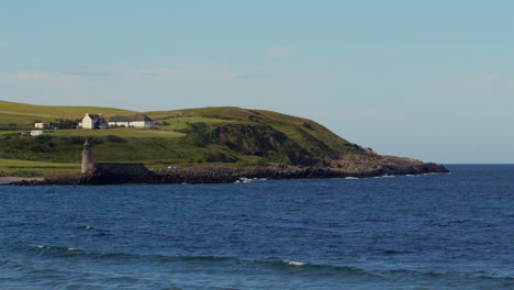 extra wide shot of port logan old lighthouse and harbour with buildings in background