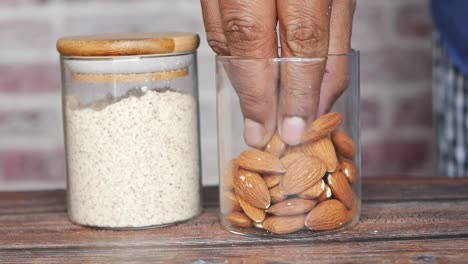 Almendra-En-Polvo-Y-Almendra-En-Un-Frasco-Sobre-La-Mesa