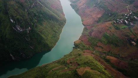 Toma-Aérea-Volando-Por-Una-Montaña-Hacia-Un-Río-En-Las-Montañas