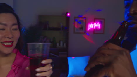 una pareja joven divirtiéndose bailando y bebiendo alcohol en una fiesta en casa juntos 2
