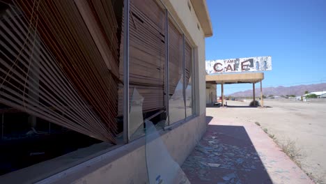 Café-Restaurante-Abandonado-En-El-Centro-Del-Desierto-De-California-Con-Ventanas-Rotas