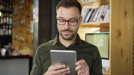 man using tablet in a coffee shop