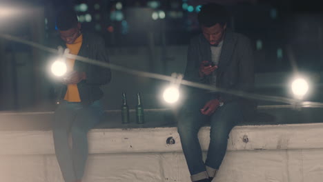 african american friends using smartphone browsing social media messages showing disinterest in rooftop party antisocial youth hanging out at night