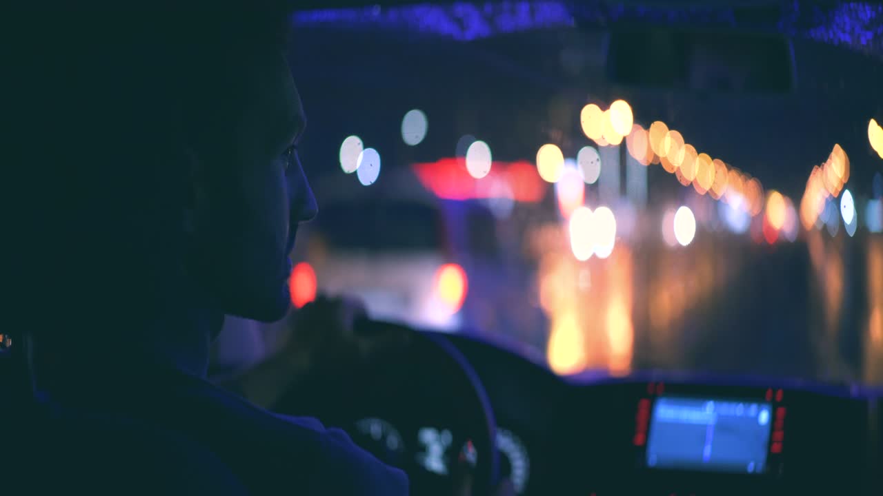 el joven conduce la máquina en la carretera nocturna