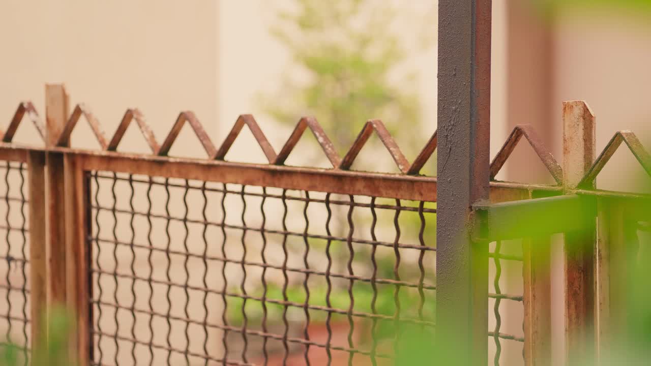 valla de tela metálica y casa residencial