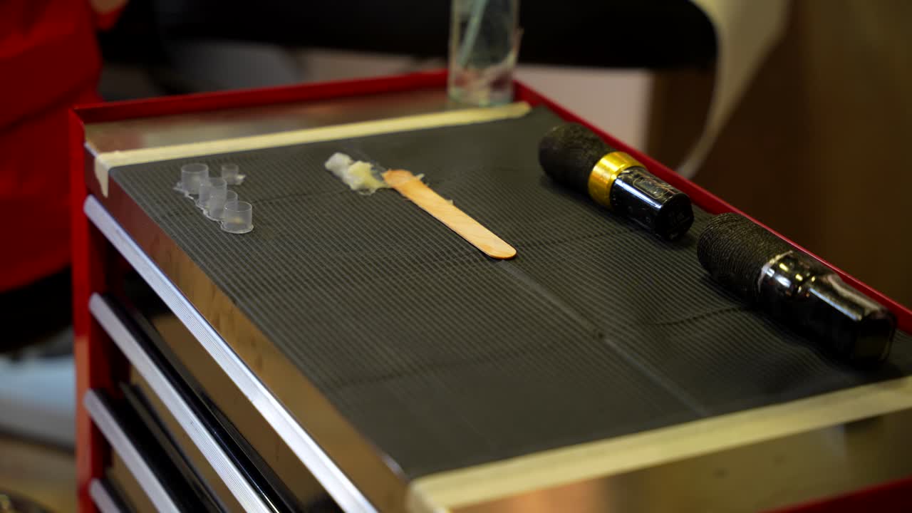 Tattoo artist working table with some tools, on top of storage cabinet at studio. Static shot