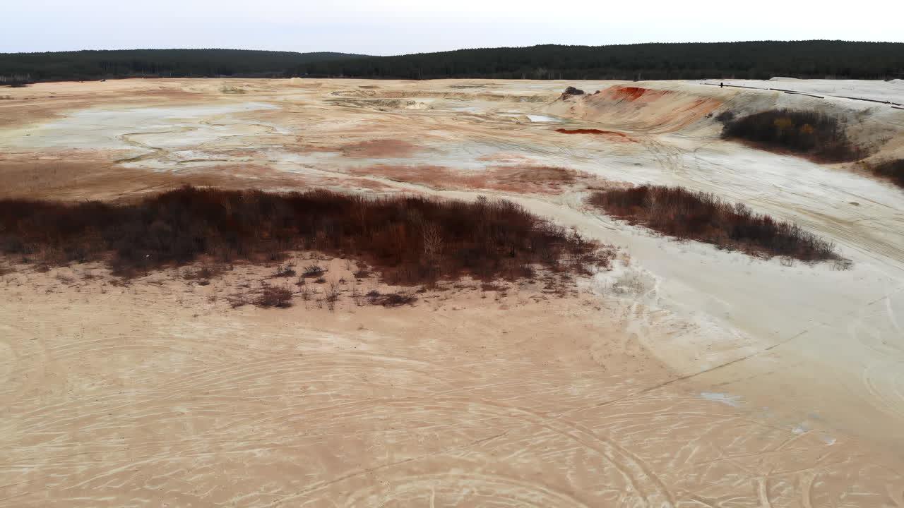 Vista aerea di una miniera a cielo aperto con terra colorata e pozze d'acqua