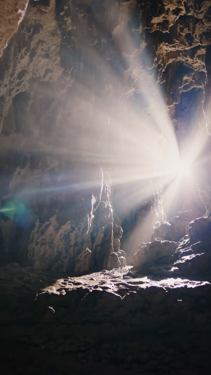 Sunlight streams into a cave, illuminating rocky textures