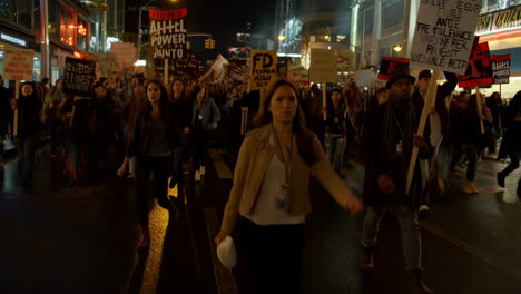 people marching and protesting on a city street at night