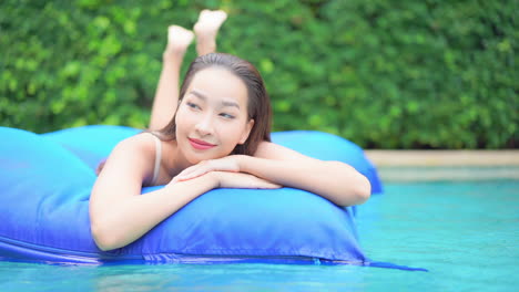 Mujer-Asiática-Flotando-En-Un-Colchón-Inflable-En-Una-Piscina---Primer-Plano