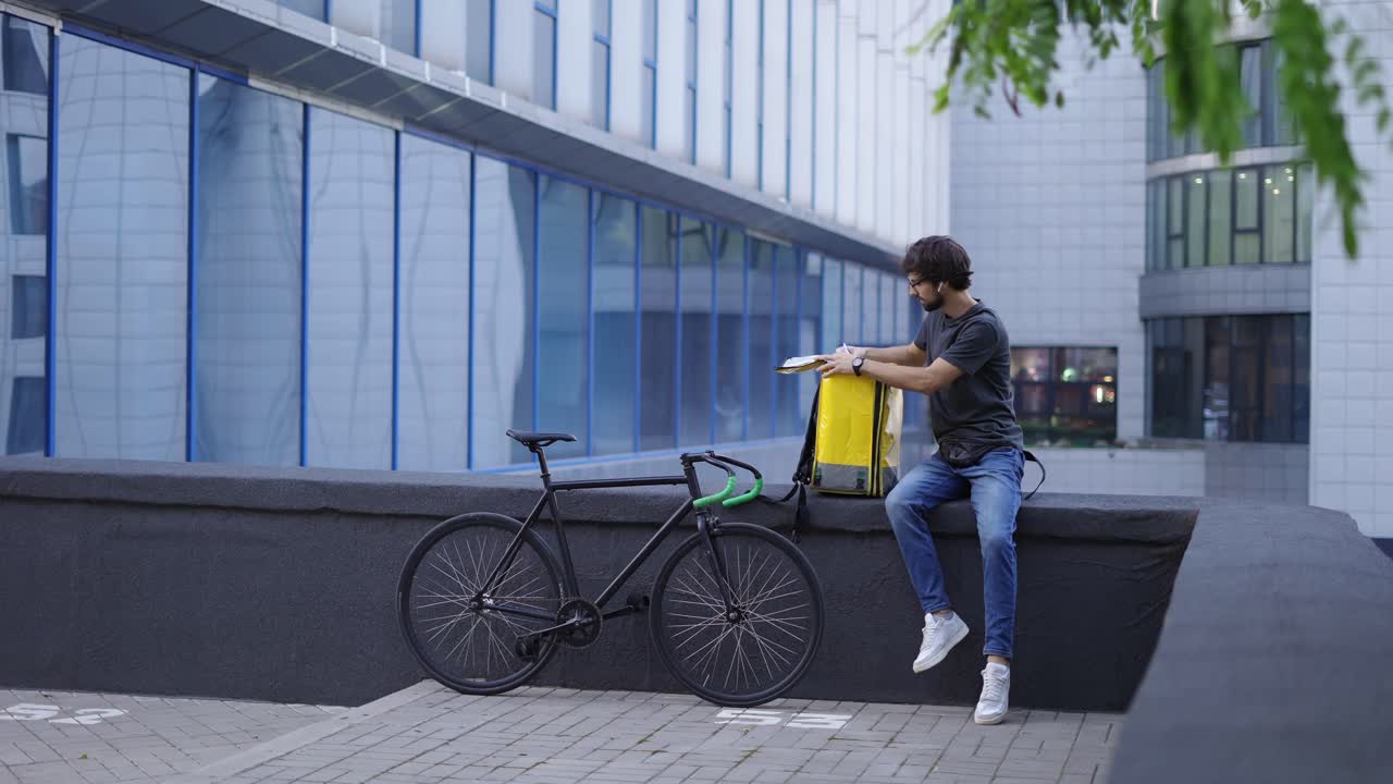 Courier with backpack look inside for details on order receipt