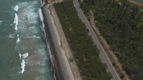 car travels down ocean road, aerial tracking shot, sea of japan, tottori