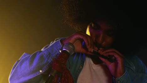 hombre tocando la armónica en un club nocturno 4k
