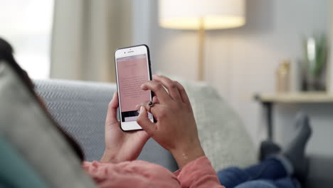 mujer relajándose en el sofá y leyendo en el teléfono